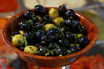 Black olives in wooden bowl on retail display