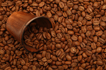 Roasted coffee beans out of brown ceramic cup