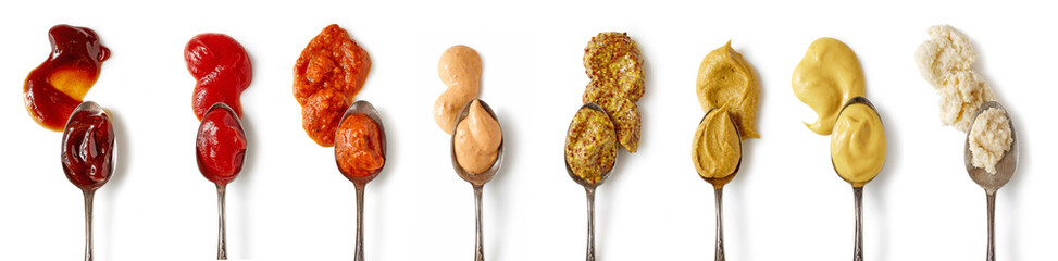Set of different sauces with spoons isolated on white background