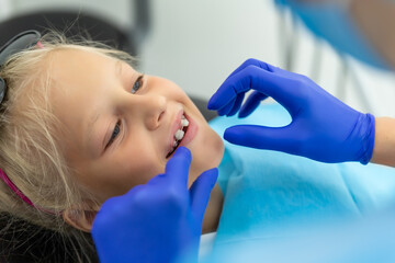 Little cute adorable happy caucasian blond kid girl at dentist office at dentist check-up of dental...
