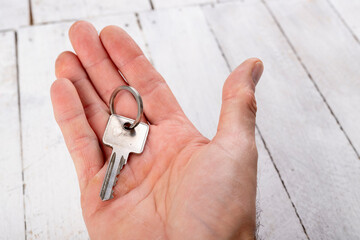 The key to the door in a single-family house held in the hand. Metal key for patent lock.
