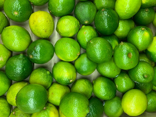 lots of ripe green lime fruit for cooking as a background