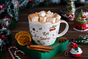 Christmas cup of cocoa with marshmallow and spices and retro toys with Christmas tree branches on background. Festive New Year card.