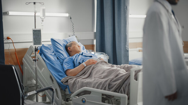 Medical Hospital Ward: Beautiful Chinese Man is Resting on a Bed. Recovering after Successful Surgery Female Patient Sleeping and Gettin Well. Modern High Tech Equipped Room