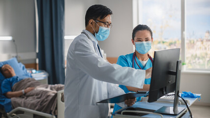 Obraz premium Hospital Ward: Chinese Doctor Talks With Professional Head Nurse, They Use High-Tech Touchscreen Computer. Health Care Specialists Checking Patient's Medical Data, Planning Further Treatment.