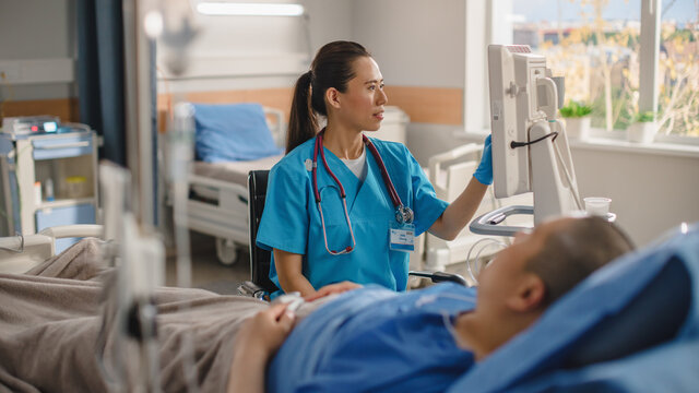 In Hospital Ward: Sick Man Lying On The Bed, His Head Nurse Hopefully Sits Beside Him Holds His Hand And Hopes For Recovery After Serious Surgery Or Dangerous Disease. Close-up Emotional Shot