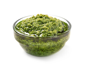 Bowl of tasty arugula pesto on white background