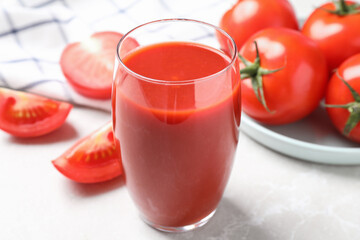 Delicious fresh tomato juice on light grey marble table table, closeup