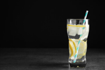 Soda water with lemon slices and ice cubes on grey table. Space for text