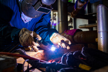 The welder is welding the work piece to the valve with Tungsten Inert Gas Welding process (TIG)....