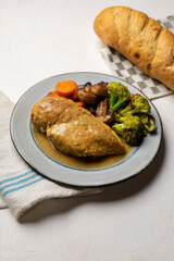 Chicken in mustard sauce with roasted vegetables in white background
