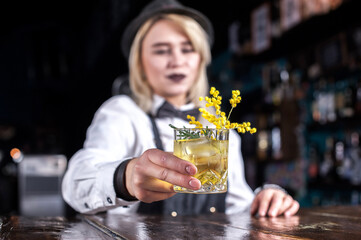 Girl bartender concocts a cocktail in the saloon