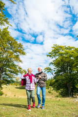 Fototapeta premium Senior couple on a walk in an autumn nature.