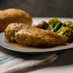 Chicken in mustard sauce with roasted vegetables in white background