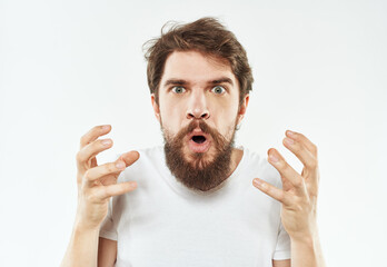 A young man in a white T-shirt gestures with his hands emotions irritability stress