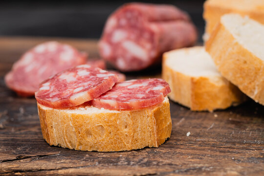 salame de la colonia tipo casero sin cascara con especies pimienta pan sobre madera  cordoba argentina