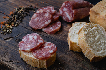 salame de la colonia tipo casero sin cascara con especies pimienta pan sobre madera  cordoba argentina