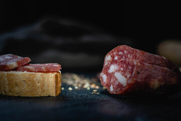 salame de la colonia tipo casero sin cascara con especies pimienta pan sobre madera  cordoba argentina