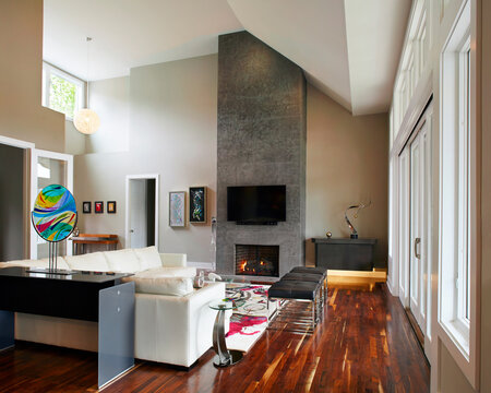 Interior modern living room with tall stone fireplace and high ceiling