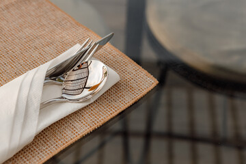 Blank white restaurant cloth napkin mockup with silver cutlery set, isolated. Knife fork and spoon...