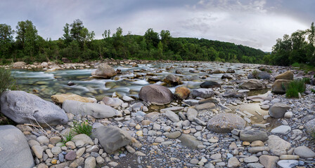 panoramic long exposure of river in spanish pyrenees with rocks
