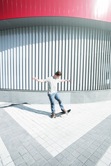 Young Caucasian male skateboarder riding a skateboard on the street.