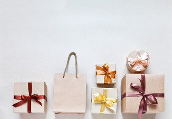 Festive composition with gift boxes on light background. Ecological packaging in kraft paper. Surprises for family celebration. Home delivery of goods. Flat lay, copy space, mock up, greeting card