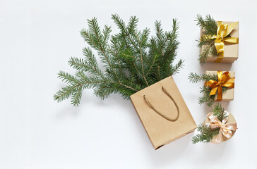 Festive Christmas composition with fir branches and gift boxes on white background. Eco-friendly packaging in kraft paper. Space for congratulatory text. Flat lay, copy space, mock up, greeting card