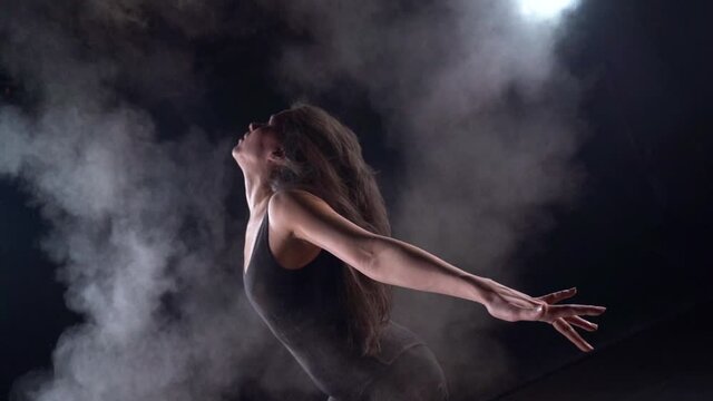 theatrical dance performance, modern woman ballet dancer is waving hair and throwing dust