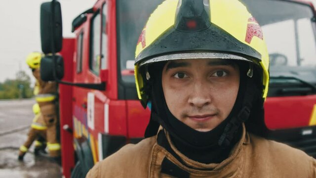 Portrait shot of the fireman in full uniform ready for the rescue. Slow motion.