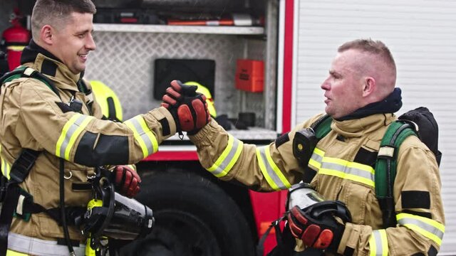 Two firefighters shaking hands after successful fire drill. High quality 4k footage