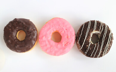 Set of four different glazed donuts on a white background.