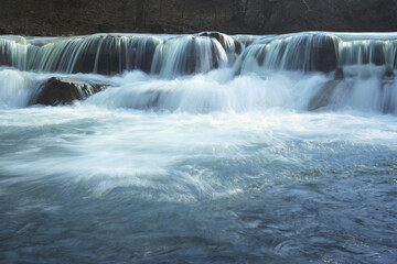 Closeup of a waterfall on a mountain stream in the fall. Mountain stream near the rocky coast in the mountains.