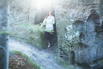 Young caucasian woman travels in the rocks in the autumn mountains.