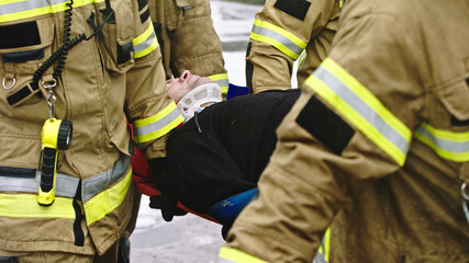 Firefghters lifting injured man. Rescue after car crash accident. High quality photo