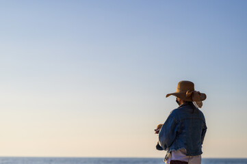  woman with hat and wearing face  travel concept new normal on beach