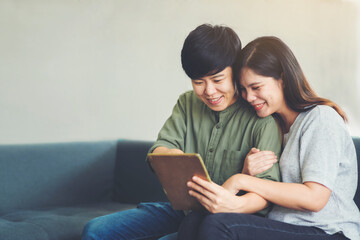 LGBT female couple who are watching their tablet and are relaxing and enjoying life together.