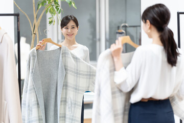 Obraz premium 洋服を試着する女性