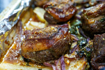 Closeup of a plate of grilled lamb chops with onions and potatoes