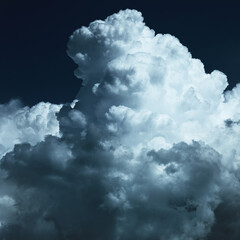 Close-up of white fluffy clouds at night in the moonlight.