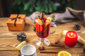 Cup of aromatic hot mulled wine on a wooden table. Concept of a festive atmosphere and traditional...