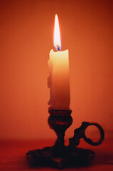 Close-up of a candle in a candlestick near the wall. The real grain of the scanned film.