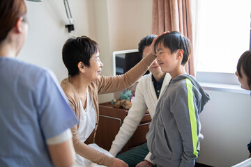 Fototapeta premium お見舞いに来た孫の頭を撫でる祖母 