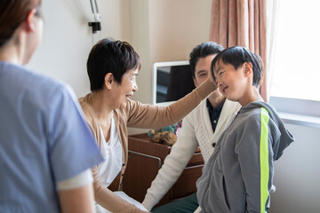 Obraz premium お見舞いに来た孫の頭を撫でる祖母 