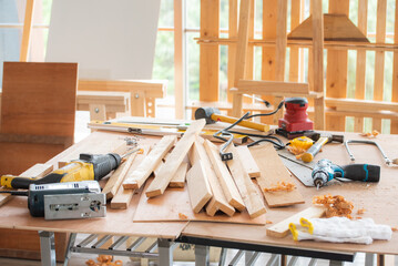 Carpenter workshop room background workbence table for wood work with electric screwdriver, saw, hammer and other tools
