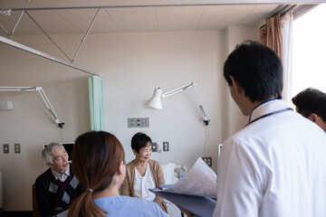 Obraz premium 入院患者のおばあちゃんをお見舞いする仲の良い家族と医師