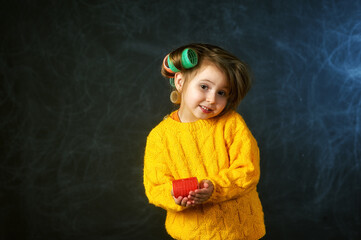 Portrait of a fashionable little beautiful girl with curlers in the Studio