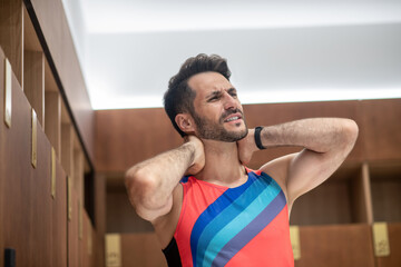 Sportsman in bright tshirt feeling unwell from pain in his neck