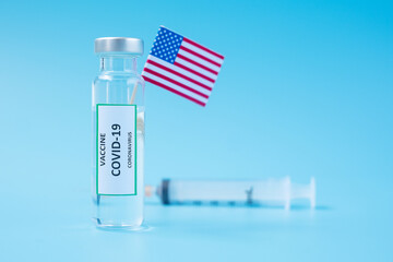 COVID-19 Vaccine vial, injection Needle Syringe and American flag against Coronavirus infection in...