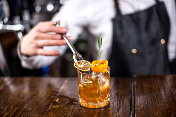 Girl bartender makes a cocktail in the pothouse